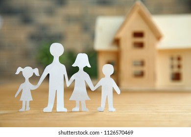 Composition With Paper Family Cutout And House Model On Table