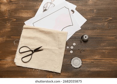 Composition with pattern and sewing accessories on wooden brown background. Top view