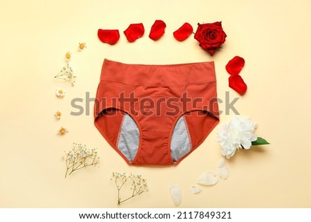 Composition with period panties and different flowers on color background