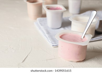 Composition with plastic cups with yogurt on white table - Powered by Shutterstock