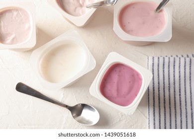 Composition with plastic cups with yogurt on white table - Powered by Shutterstock