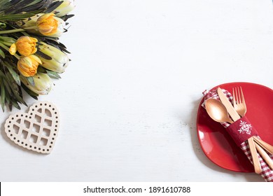 Composition with a plate and cutlery for a romantic dinner and decorative elements Valentine's Day top view. Dating concept.