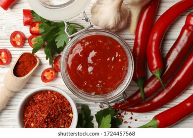 Composition With Red Hot Sauce And Ingredients On Wooden Background