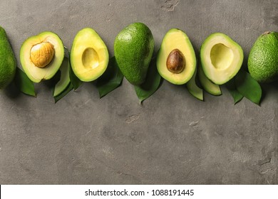 Composition with ripe avocados on dark grey background