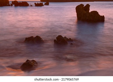 composition of rocks emerging from the sea among silky water