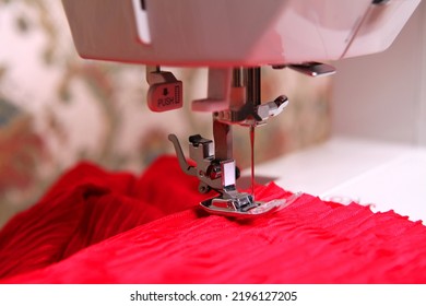 Composition from a sewing machine. Mannequin, flowers on a retro table and threads. Sewing supplies and composition with a sewing machine in the interior. The composition is unique for the fashion.