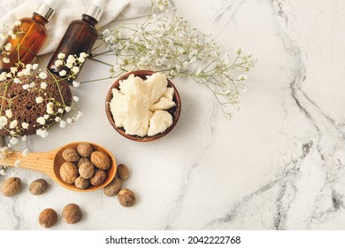 Composition With Shea Butter, Nuts And Essential Oil On Light Background