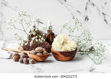 Composition With Shea Butter, Nuts And Essential Oil On Light Background