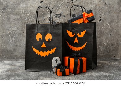 Composition with shopping bags, gift boxes and tasty cookie for Halloween on grunge grey background - Shutterstock ID 2341558973