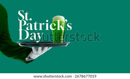 Composition of St Patrick Day green beer glass on silver tray with white glove hand. Concept of Irish holiday, tradition, pub party, festive beverage, joyful culture, and cheerful seasonal celebration
