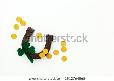Composition for St. Patrick's Day. Decorating paper with green clover or shamrocks, gold coins and horseshoe.