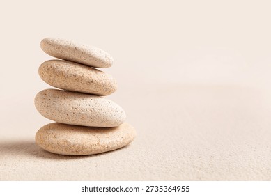 Composition with stack of spa stones on light sand as background, closeup. Zen concept