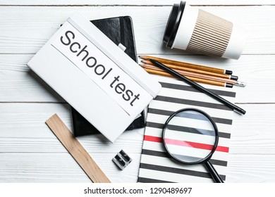 Composition with stationery and text SCHOOL TEST on table
