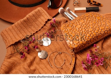 Composition with stylish female accessories, cosmetics, clothes and flowers on color background, closeup