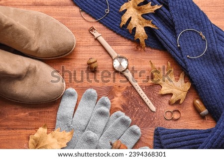 Composition with stylish female accessories, shoes and fallen leaves on wooden background