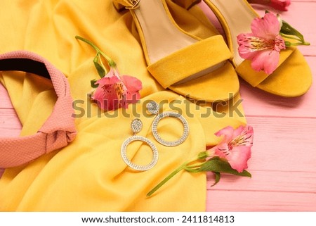 Composition with stylish female accessories, shoes and alstroemeria flowers on color wooden background, closeup