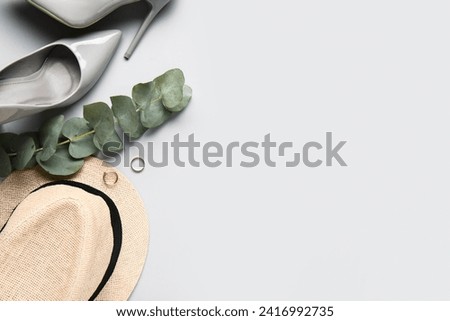 Composition with stylish female accessories, shoes and eucalyptus branch on light background