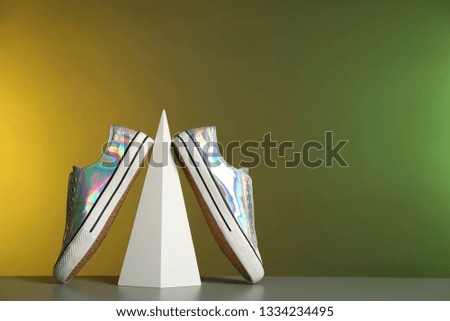 Composition with stylish shoes on table against color background. Space for text