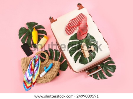 Composition with suitcase, beach accessories, vibrator and mobile phone on pink background