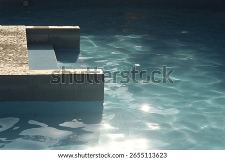 composition of a swimming pool corner under midday sun, showcasing shimmering turquoise water, clean lines, and textured tiles creating a tranquil and abstract visual balance.
