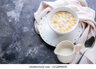 Composition with tasty cornflakes and milk on dark background