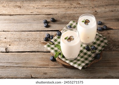 Composition with tasty yogurt in glasses and blueberries on wooden table. Space for text - Powered by Shutterstock