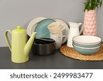 Composition with teapot and different kitchen stuff on black table