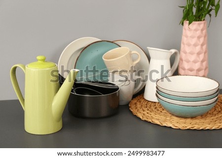Composition with teapot and different kitchen stuff on black table