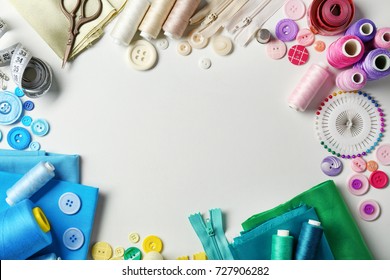Composition with threads and sewing accessories on white background