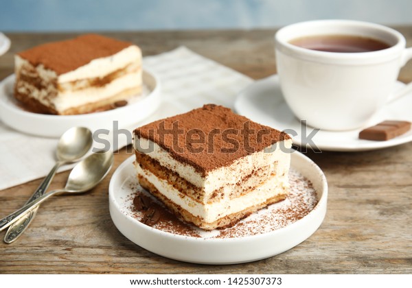 Composition with\
tiramisu cakes and tea on\
table