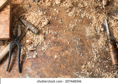 Composition Of Two Antique Chisels, Hammer, Pincers And Wood Chips On The Working Desk In Wood Workshop.