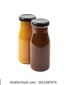 Composition Of Two Sauce Condiments In Glass Jar Bottles Next To Each Other, Isolated Over The White Background