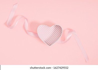 Composition for Valentine's day. Holiday pink background with gift, white satin bow, ribbon. Valentines Day, Easter, Happy Women's Day, Mother's day. Flat lay, top view, copy space Composition for Valentine's day. Holiday pink background with gift, white satin bow, ribbon. Valentines Day, Easter, Happy Women's Day, Mother's day. Flat lay, top view, copy space