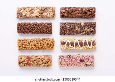 Composition With Various Cereal Bars On White Background, Sugar, Chocolate And Muesli, Coca And Corn Flakes