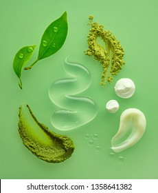 composition of various organic cosmetic products on green background, top view