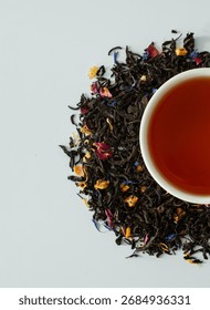Composition with various types of tea, a cup of brewed tea, and loose tea on a white background