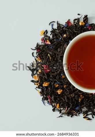 Composition with various types of tea, a cup of brewed tea, and loose tea on a white background