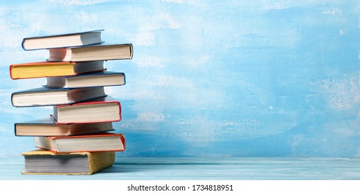 Composition with vintage old hardback books, diary, fanned pages on wooden deck table and abstract background. Books stacking. Back to school. Copy Space. Education background. - Shutterstock ID 1734818951