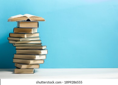 Composition with vintage old hardback books, diary, fanned pages on wooden deck table and red background. Books stacking. Back to school. Copy Space. Education background. - Shutterstock ID 1899286555