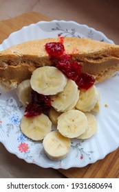 composition  white bread sandwich and peanut butter  banana slices  berry jam