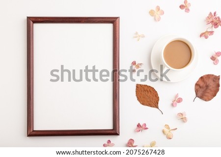 Composition with wooden frame, brown beech autumn leaves, hydrangea flowers and cup of coffee. mockup on white background. Blank, flat lay, top view, still life, copy space.
