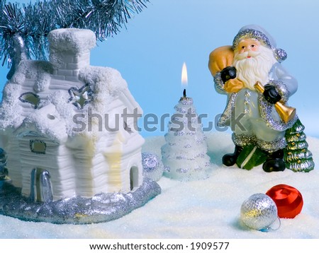 Compositions with Santa Claus, fabulous house and candle.