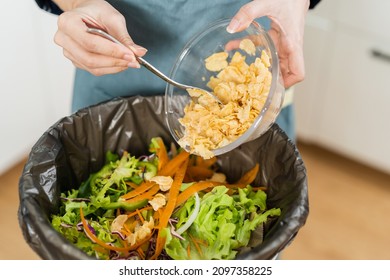 Compost the kitchen waste, recycling, organic meal asian young household woman scraping, throwing food leftovers into the garbage, trash bin from vegetable. Environmentally responsible, ecology. - Shutterstock ID 2097358225
