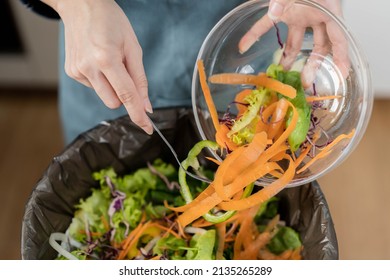 Compost the kitchen waste, recycling, organic meal asian young household woman scraping, throwing food leftovers into the garbage, trash bin from vegetable. Environmentally responsible, ecology. - Shutterstock ID 2135265289