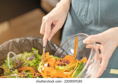 Compost The Kitchen Waste, Recycling, Organic Meal Asian Young Household Woman Scraping, Throwing Food Leftovers Into The Garbage, Trash Bin From Vegetable. Environmentally Responsible, Ecology.