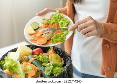 Compost From Leftover Food, Asian Young Housekeeper Woman Hand Holding Cutting Board Use Fork Scraping Waste, Rotten Vegetable Throwing Away Into Garbage, Trash Or Bin. Environmentally Responsible.