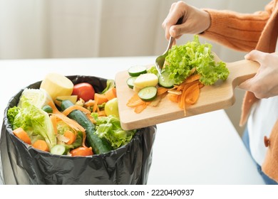 Compost From Leftover Food, Asian Young Housekeeper Woman Hand Holding Cutting Board Use Fork Scraping Waste, Rotten Vegetable Throwing Away Into Garbage, Trash Or Bin. Environmentally Responsible.