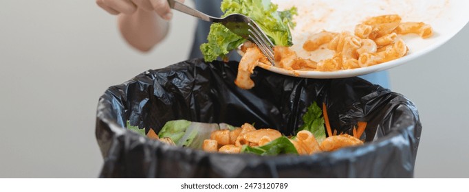 Compost from leftover food in the meal in household, female hand holding left over meal use fork scraping waste, rotten vegetable throwing away into garbage, trash or bin. Environmentally responsible - Powered by Shutterstock