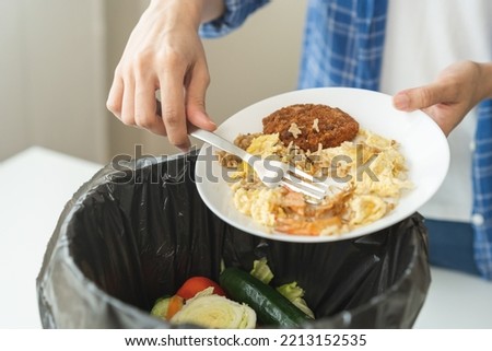 Compost from leftover food, refuse asian young housekeeper woman, girl hand using fork scraping waste from dish, throwing away putting into garbage, trash or bin.
Environmentally responsible, ecology. [[stock_photo]] © 