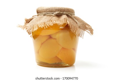 Compote of peaches in a glass jar on white background